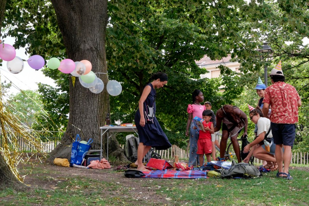 Photo couleur. Marseille, parc Longchamp : un groupe, parents, enfant dans le parc pour l'anniversaire d'un enfant. Guirlande et ballons de baudruche sur un fil.
